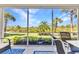 Enclosed patio with furniture overlooking a lush tropical view with blue skies at 3393 Grand Vista Ct # 101, Port Charlotte, FL 33953