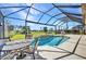 Enclosed swimming pool with a water feature and outdoor dining area overlooking the golf course at 3511 Bay Ridge Way, Port Charlotte, FL 33953