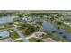 Aerial view of a home with a screened pool and canal frontage in a residential neighborhood at 380 Concordia St, Punta Gorda, FL 33983