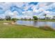 A picturesque backyard featuring a calm lake, lush green lawn, and serene neighborhood views at 380 Concordia St, Punta Gorda, FL 33983