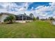 Lush backyard with a view of the screened-in patio and lake, providing a serene outdoor space at 380 Concordia St, Punta Gorda, FL 33983