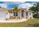 Inviting front entrance with decorative pillars, lush landscaping, and well-manicured lawn at 380 Concordia St, Punta Gorda, FL 33983