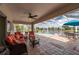 Screened patio with outdoor furniture, ceiling fan, and a tranquil lake view at 380 Concordia St, Punta Gorda, FL 33983
