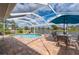 Screened patio with a pool, a dining table and chairs, and a backyard with lake view at 380 Concordia St, Punta Gorda, FL 33983