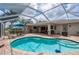 A refreshing pool area with a screened enclosure, comfortable patio furniture, and outdoor cooking facilities at 380 Concordia St, Punta Gorda, FL 33983