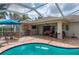 A cozy pool area with outdoor seating, a grill, and a view of the spacious backyard at 380 Concordia St, Punta Gorda, FL 33983