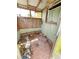 Enclosed outdoor bathroom with brick floor and adjacent wood paneled storage room at 4222 Gardner Dr, Port Charlotte, FL 33952