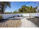 Backyard featuring a gravel fire pit area and palm trees, surrounded by a white fence at 4373 Atwater Dr, North Port, FL 34288