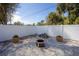 Cozy backyard with a gravel fire pit area and potted plants, enclosed by a white fence at 4373 Atwater Dr, North Port, FL 34288