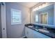 Bathroom featuring a double vanity with granite countertops, gray walls, and wood-look floors at 4373 Atwater Dr, North Port, FL 34288