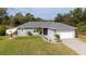 Charming single-story home with a well-manicured lawn, stone landscaping, and a paved driveway leading to the garage at 4373 Atwater Dr, North Port, FL 34288