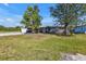 Charming single-story home featuring mature trees, a front lawn, and a driveway leading to the garage at 628 Tarpon Way, Punta Gorda, FL 33950