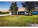 Charming single-story home featuring mature trees, a front lawn, and a driveway leading to the garage at 628 Tarpon Way, Punta Gorda, FL 33950