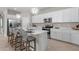 Modern kitchen with stainless steel appliances, white cabinetry, and a breakfast bar with seating at 7931 Lakes Edge Ln, Port Charlotte, FL 33981