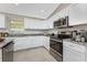 Updated kitchen featuring stainless steel appliances, granite countertops, and white cabinetry at 8905 Sawyer Cir, North Port, FL 34288