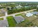 Overhead view of a modern home featuring a well-manicured lawn and easy access to surrounding community streets at 12156 Wellington Ave, Port Charlotte, FL 33981