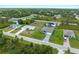 Wide aerial view showcasing the property's location within a lush, green neighborhood and surrounding houses at 12156 Wellington Ave, Port Charlotte, FL 33981