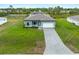 Birds eye view of a single Gathering home with a gray brick driveway, well-kept lawn, and simple landscaping at 12156 Wellington Ave, Port Charlotte, FL 33981