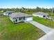 An aerial shot of a well-manicured single Gathering home with a gray brick driveway and lovely landscaping at 12156 Wellington Ave, Port Charlotte, FL 33981