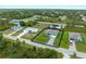 Aerial view of a cozy single-Gathering home with well-maintained landscaping and gray brick driveway at 12156 Wellington Ave, Port Charlotte, FL 33981