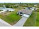 Aerial view of a single-Gathering home with a well-maintained lawn and paved driveway in a suburban neighborhood at 12156 Wellington Ave, Port Charlotte, FL 33981