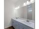 Bathroom features a double sink vanity, modern fixtures, and a view to the tiled shower at 12156 Wellington Ave, Port Charlotte, FL 33981