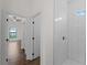 Shower features white tiling, a small window, and modern fixtures, with a view to the bedroom at 12156 Wellington Ave, Port Charlotte, FL 33981