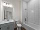 Bathroom features modern fixtures, white tiling, white sink, toilet, and a view to the hallway at 12156 Wellington Ave, Port Charlotte, FL 33981