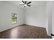 Well-lit bedroom with tile floors, a ceiling fan, and a window with a view of the backyard at 12156 Wellington Ave, Port Charlotte, FL 33981