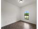 Bedroom featuring wood-look tile flooring, white walls, and a window with a view outside at 12156 Wellington Ave, Port Charlotte, FL 33981