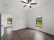 Bright bedroom with tile flooring, ceiling fan, and a window providing natural light and outdoor views at 12156 Wellington Ave, Port Charlotte, FL 33981
