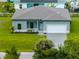 Charming single-story home featuring a well-manicured lawn, gray driveway, and a welcoming two-car garage at 12156 Wellington Ave, Port Charlotte, FL 33981
