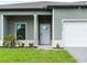 Close up of a new home featuring a two-car garage, covered porch, and well-manicured lawn at 12156 Wellington Ave, Port Charlotte, FL 33981