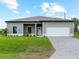 Charming single-story home featuring a two-car garage, well-maintained lawn, and lovely curb appeal at 12156 Wellington Ave, Port Charlotte, FL 33981