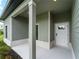 Covered front porch featuring neutral colors and modern design, offering a welcoming entrance to the home at 12156 Wellington Ave, Port Charlotte, FL 33981
