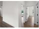 Hallway with wood-look tile flooring and white walls, doorways to bedrooms featuring windows at 12156 Wellington Ave, Port Charlotte, FL 33981