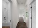 Hallway with wood-look tile flooring, white walls, and white trim, with doorways to bathroom and bedroom at 12156 Wellington Ave, Port Charlotte, FL 33981