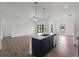 Bright, open kitchen boasts modern appliances and a center island with a sink and quartz countertop at 12156 Wellington Ave, Port Charlotte, FL 33981