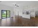 Spacious living room with tile flooring, modern ceiling fan, and an open layout to the kitchen with stainless appliances at 12156 Wellington Ave, Port Charlotte, FL 33981