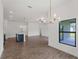 Open-concept living area featuring modern lighting, a kitchen island, and large windows with outdoor views at 12156 Wellington Ave, Port Charlotte, FL 33981