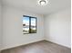 Modern bedroom with wood-look floors and a large window providing natural light at 14319 Allensworth Ave, Port Charlotte, FL 33981