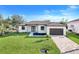 Charming single-story home with a well-manicured lawn, a paved driveway, and a two-car garage at 14319 Allensworth Ave, Port Charlotte, FL 33981