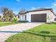 Beautiful curb appeal with a brick paver driveway leading to a modern two-car garage at 14319 Allensworth Ave, Port Charlotte, FL 33981