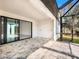 Covered patio with stone flooring and screened enclosure to backyard at 14319 Allensworth Ave, Port Charlotte, FL 33981