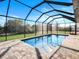 Sparkling pool enclosed in a screened lanai with brick-paver decking at 14319 Allensworth Ave, Port Charlotte, FL 33981