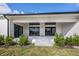 The home's back patio features a gray concrete surface, sliding glass doors, and green bushes at 16440 Cape Horn Blvd, Punta Gorda, FL 33955