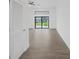 This hallway features wood-look tile flooring, white walls, and a decorative light fixture at 16440 Cape Horn Blvd, Punta Gorda, FL 33955