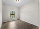 Bright bedroom with wood-look tile flooring and a window bringing in natural light at 17323 Elmwood Ave, Port Charlotte, FL 33948