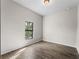Bright bedroom with wood-look tile flooring and a window bringing in natural light at 17323 Elmwood Ave, Port Charlotte, FL 33948