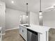 Modern kitchen island with quartz countertop, stainless steel sink, and dishwasher, complemented by pendant lighting at 17323 Elmwood Ave, Port Charlotte, FL 33948
